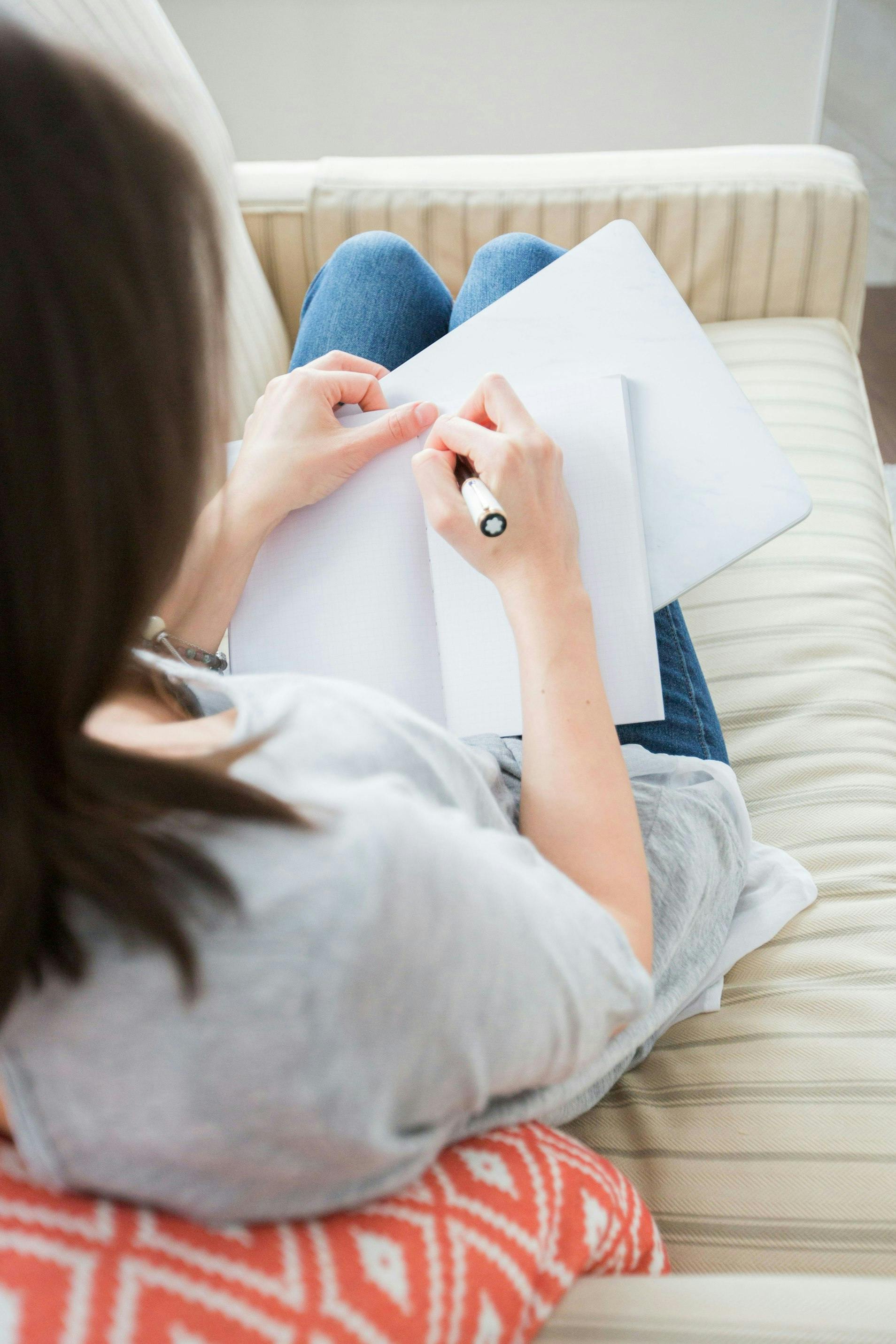 Woman writing on a blank notebook